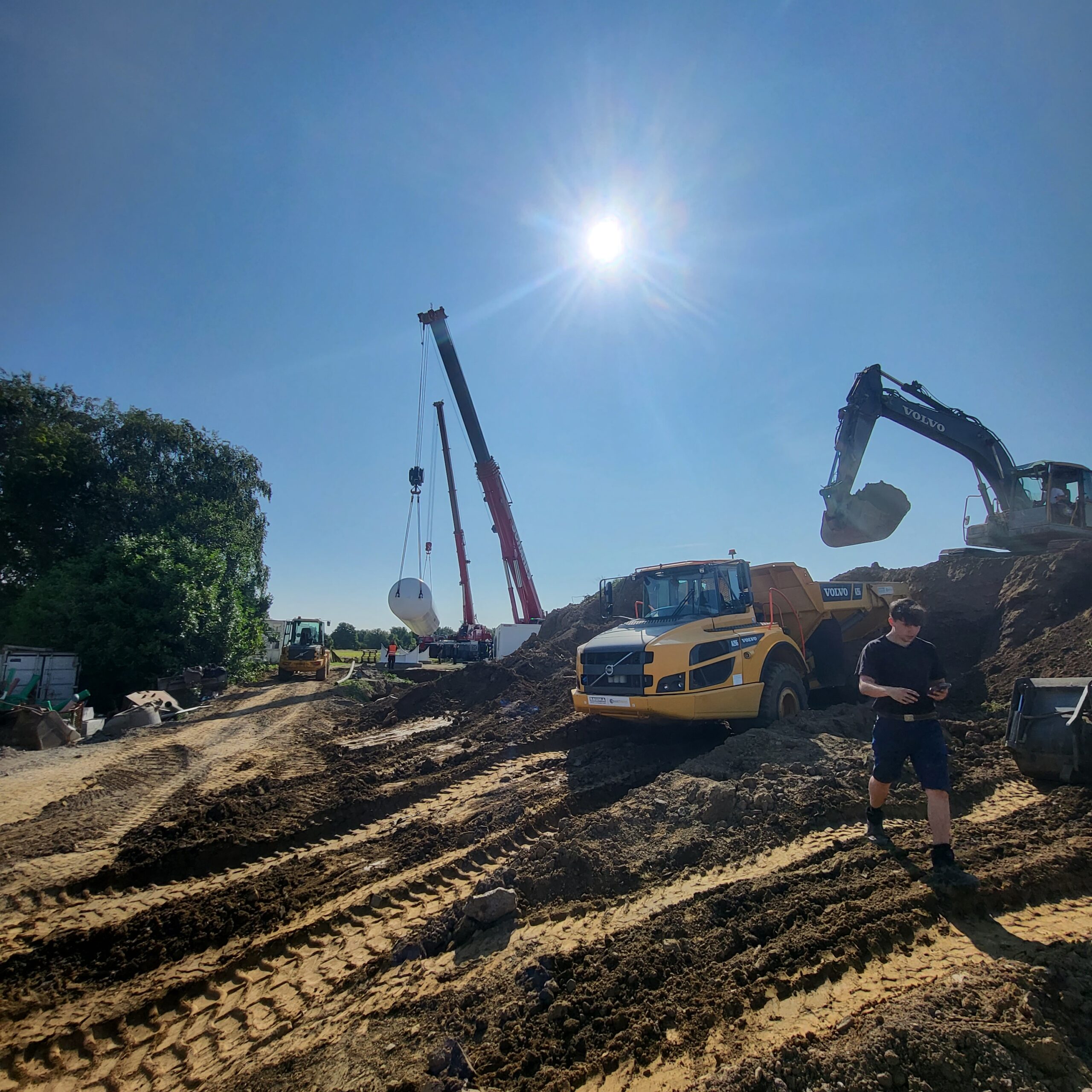 Bagger auf einem Erdwall in freier Landschaft im Umland von Essen